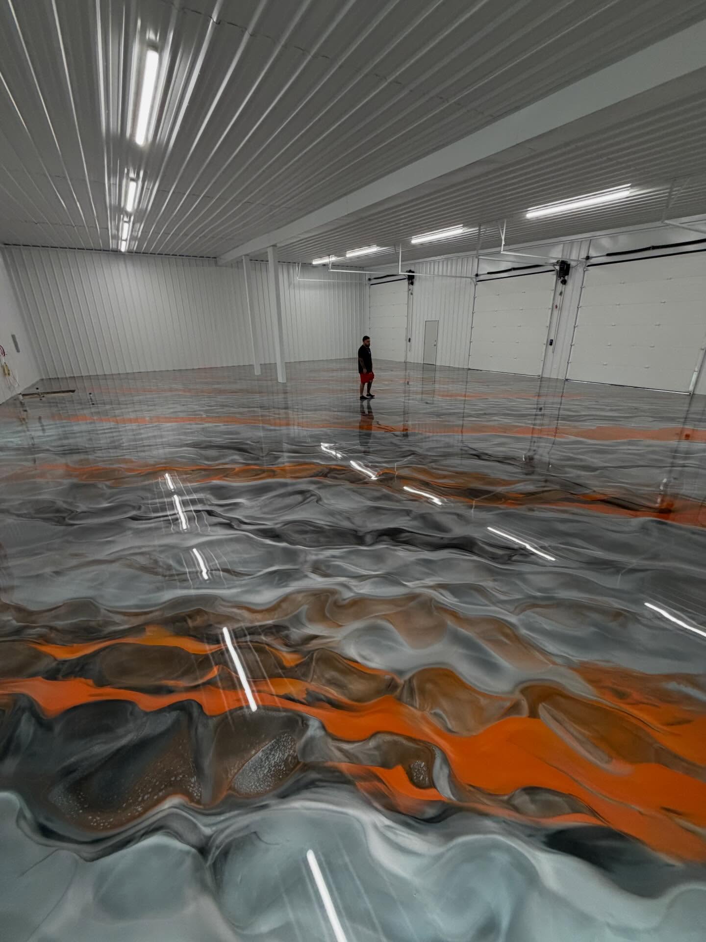 Orange, graphite, and silver metallic floor flowing through a large room.